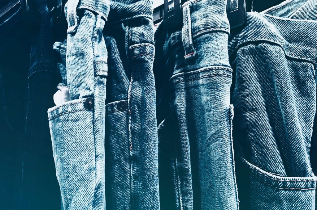A set of blue jeans hanged to the hanger